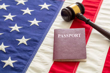Passport and judge gavel on USA flag background, closeup view. Immigration, United States of America visa conceptの写真素材