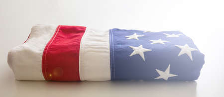 USA flag folded on white background. American flag closeup view. Memorial day and 4th of July, Independence day concept. Card, poster templateの写真素材