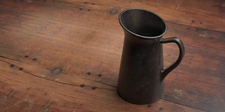 Jug against wood table background. Milk pitcher, metal container with handle to hold liquids, above view, copy space. 3d illustrationの写真素材
