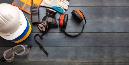 Work safety protection equipment flat lay. Industrial protective gear on blue wooden background. Construction site health and safety concept, copy space.の写真素材