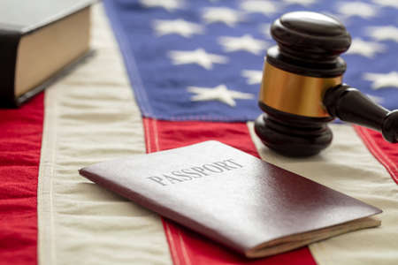 Passport and judge gavel on USA flag background, closeup view. Immigration, United States of America visa conceptの写真素材