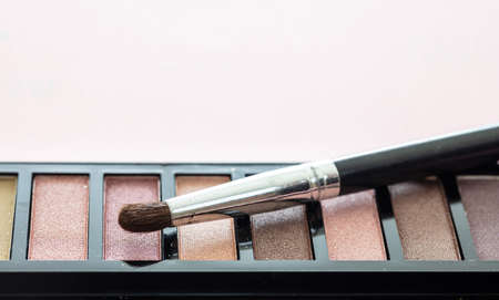 Eyeshadows pallete set pastel colors and brush against pink background, closeup view. Professional tools for make up, beauty salon, cosmetics conceptの写真素材