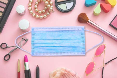 Coronavirus and beauty fashion concept. Protective face mask and essentials female accessories against pink color background, copy space. COVID19 disease prevention,の写真素材