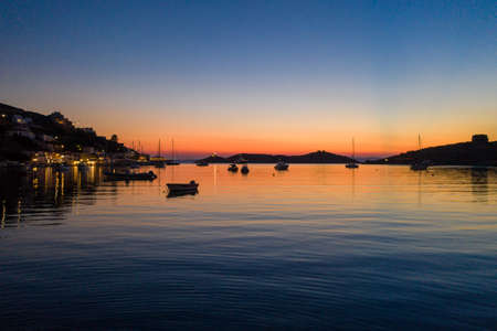 Kea Tzia island, Cyclades, Greece. Vourkari marina at sunset. Sailboats and sky, reflections on calm waterの写真素材