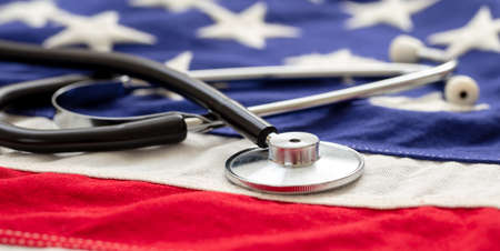 USA health care. Medical stethoscope on a US of America flag, banner. American health insurance conceptの写真素材