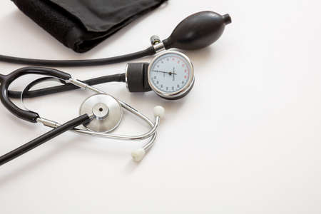 Blood pressure measure equipment, Hypertension control. Medical stethoscope and sphygmomanometer on white color background, closeup view.の写真素材