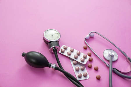 Blood pressure meter, medical stethoscope and medicine on violet color background, close up view. Hypertension treatment, medication conceptの写真素材
