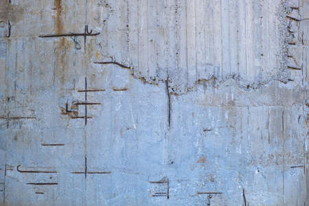 Reinforced concrete with damaged and rusty steel reinforcement. Old distressed wall texture...