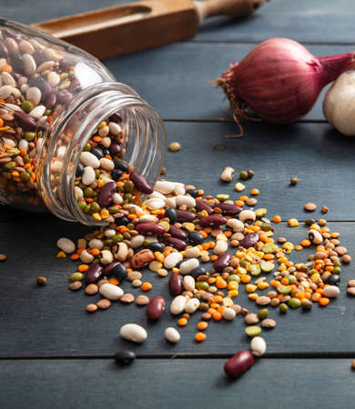 Legumes pulses mix on blue tabletop background. Dry mixture for vegetarian healthy food, italian...