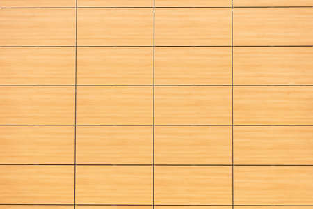Wood tiles building facade background, texture. Wooden wall finishing, modern exterior building...
