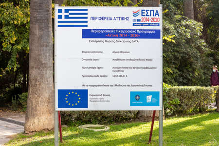 Athens Greece, November 19, 2020. Information billboard sign in greek language at National Garden.  European Union financing for park upgrating, sunny day.のeditorial素材