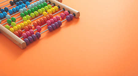 School abacus with colorful beads on orange color background, close up view, copy space. Kids learning count, children math class conceptの写真素材