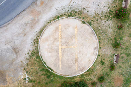 Helicopters landing area. Aerial drone view of helipad sign. Heliport signal with yellow color letter H on ground, make us feel safe in case of emergency.の写真素材