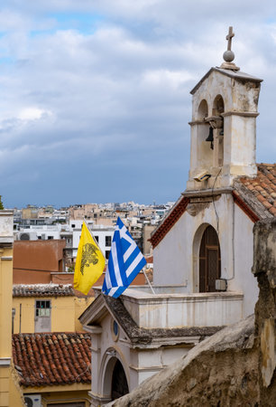 Athens Greece. Greek and byzantine flags on Panagia Chrysokastriotissa Christian Orthodox Church,12th century stone building at Anafiotika, Plaka. Destination, tourist attraction.の写真素材