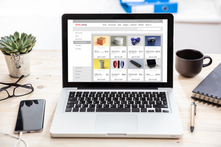 Online shop website, Eshop, ecommerce, digital marketing web page on a laptop screen, office desk background.の写真素材