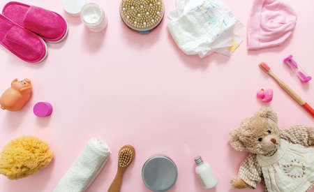 Baby bath accesories flat lay. Girl clothes and supplies on pink background, top view. Newborn bathing, diaper change and body care productsの写真素材