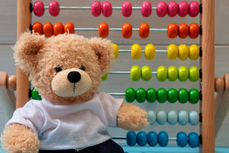 Kids learning count, children math class concept. Cute teddy bear, school abacus with colorful beads backgroundの写真素材