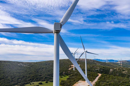 Wind farm, Wind turbines and curvy road on the hill, Green ecological power energy generation....