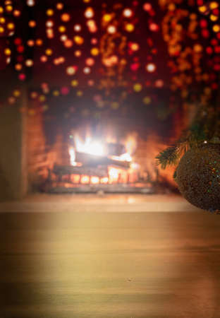 Xmas interior home celebration concept. Vertical close up view of Christmas tree branch with silver golden sparkle ball and bokeh blur burning fireplace background, copy space. Warm family moments.の写真素材