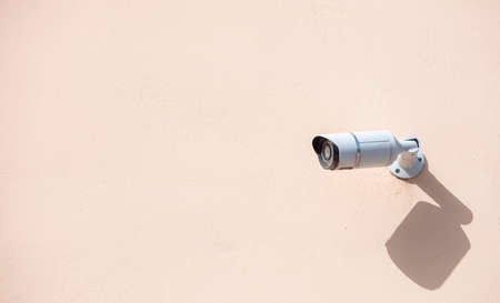 Security Camera CCTV. Surveillance cam isolated on painted wall background, copy spaceの写真素材