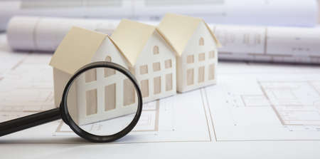 Construction blueprints, detailed design concept. Residence architectural drawings and magnifier glass. Architect engineer work space, office desk.の写真素材