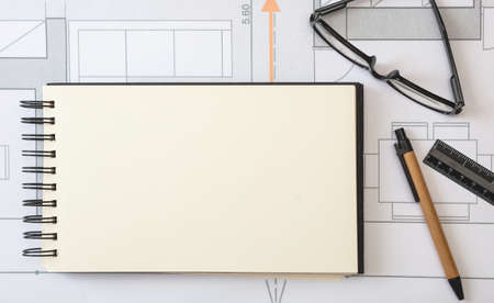 Architect engineer blank notebook, project blueprints background. Real estate design, construction site office concept.の写真素材