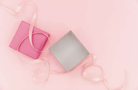 Gift box pink color on pink background. Package open and empty with ribbon, girl birthday present...