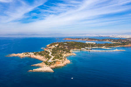 Athens Greece riviera coast, Vouliagmeni, panoramic aerial drone view of the bay and peninsula, south coast. Cloudy blue sky, calm sea waterの写真素材