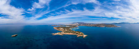 Greece Athens riviera coast, Vouliagmeni, panoramic aerial drone view of the bay and peninsula, south coast. Cloudy blue sky, calm sea waterの写真素材