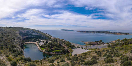 Athens Greece riviera coast, Vouliagmeni. Panoramic view over the lake and nearby area on the south. Famous lake and cave aerial drone birds eye view, cloudy blue skyの写真素材