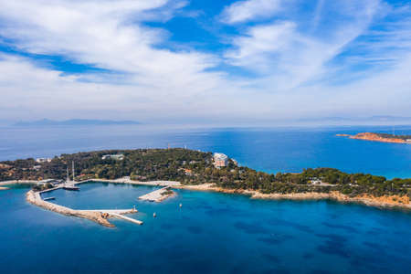 Athens Greece riviera coast, Asteras Vouliagmeni. Aerial drone view of the bay and peninsula, south coast. Cloudy blue sky, calm sea waterの写真素材