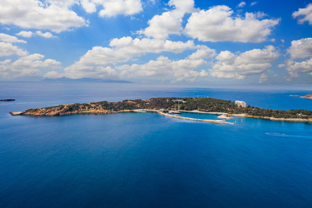 Greece Athens riviera coast, Asteras Vouliagmeni. Aerial drone view of the bay and peninsula, south coast. Cloudy blue sky, calm sea waterの写真素材