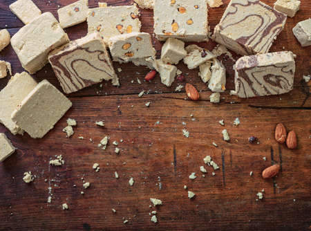 Halva variety cocoa and almonds on wooden table background, copy space, template. Halvah or halwa pieces, traditional dessert confection made with sunflower seeds or sesame tahini.の写真素材