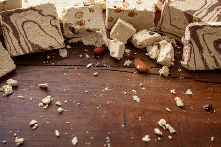 Halvah variety cocoa and almonds on wooden table background, copy space, template. Halva or halwa pieces, traditional dessert confection made with sunflower seeds or sesame tahini.の写真素材