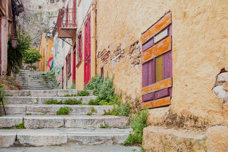 Old town Plaka, Athens destination Greece. Aged empty traditional stone stairs from down to upper, narrow pedestrian streets, peeled multicolored buildings walls at landmark background.の写真素材