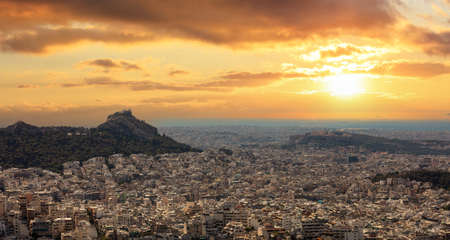 Athens, Greece cityscape, Panoramic view of the city, Acropolis hill and Lycabettus mount at sunset, orange color skyの写真素材