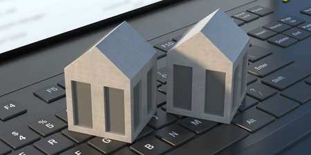 Modern model houses on laptop keyboard background. Technology and home concept. Close up of...