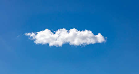 Cloud white on blue sky. One single fluffy cloud isolated on clear sky background, sunny spring day.の写真素材