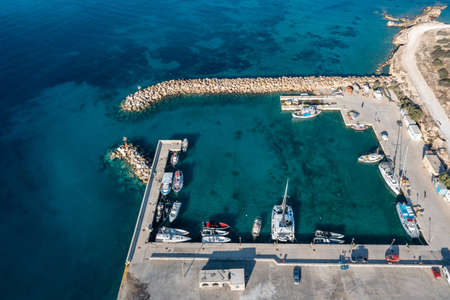 Greece, Koufonisi island, small Cyclades. Marina aerial drone view. Fishing boats and sailboats anchored at the port.  Calm emerald color sea water background.の写真素材