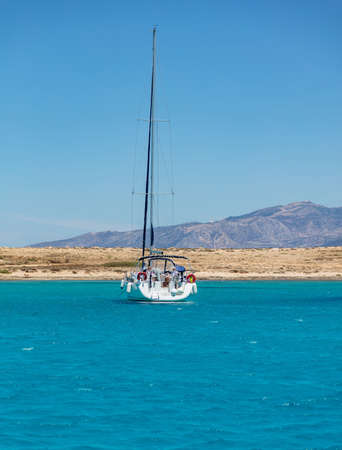 Koufonisi island, Pori beach, Cyclades, Greece. May 22, 2021. Sailing boat anchored in the middle of Aegean calm sea blue sky background. Sunny summer day, destination, relax, fishing, vacation.のeditorial素材