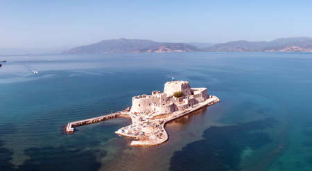 Greece, Bourtzi, Venetian water fortress at the entrance of Nafplio harbour. Aerial drone view. Blue...