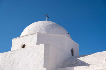 Greece, Cyclades. Folegandros island, Old church dome at Chora town. Traditional Cycladic chapel, whitewashed walls, clear blue sky background. Copy space, card templateの写真素材