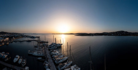 Greece, Paros island. Cyclades. May 25, 2021. Parikia port marina aerial drone view at sunset. Sun falling over the calm sea, boats moored at harbour. Aegean sea sailing, summer vacationsのeditorial素材