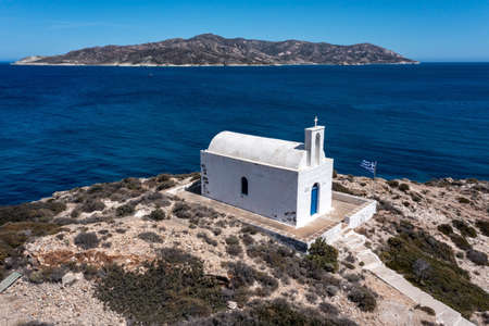 White small church at Kimolos island, Psathi port, aerial drone view. Rocky landscape, calm Aegean Sea, blue sky background. Greece Cyclades. Sunny windy dayの写真素材