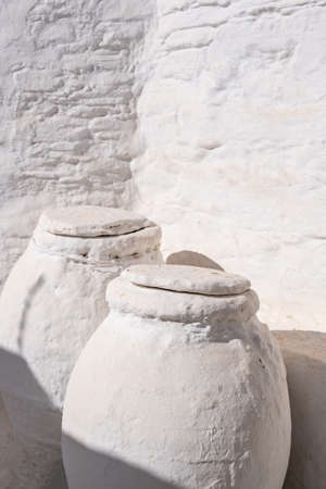 Ceramic Pots, Greek pithari covered with stone painted white outdoors in a house at Sifnos island, Greece, Cyclades. Handmade pottery traditionの写真素材