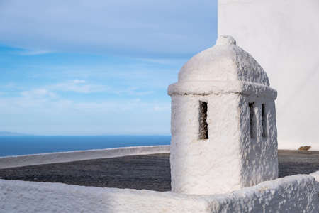 Curving chimney whitewashed old structure with holes on top of building roof at Serifos island,...