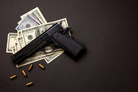Criminal money, mafia and corruption concept, Crime concept, pistol handgun 9 mm and American dollar banknotes on black background.の写真素材