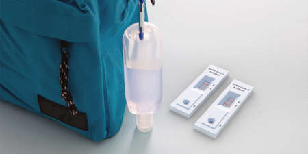 Schoolprotection concept. Rapid test, hand sanitizer and student backpack on white color background,...