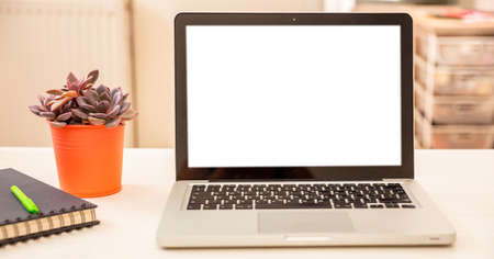 Blank screen computer laptop on a white office desk, blur room interior background. Copy space, templateの写真素材