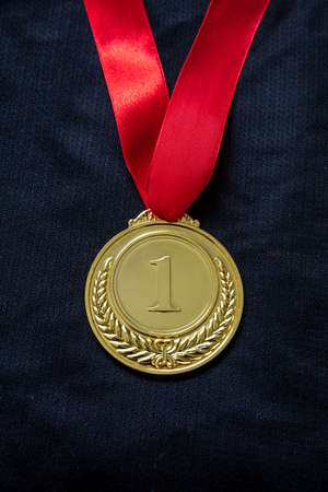 Medal gold, Winner prize award hanging with red color ribbon on athlete chest. Golden trophy in...